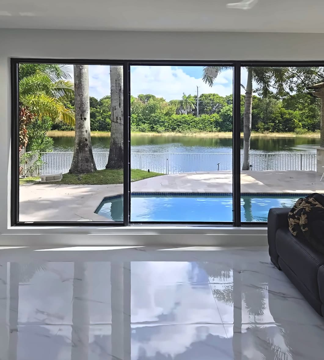 Black-framed glass wall looking out to a pool and a lake